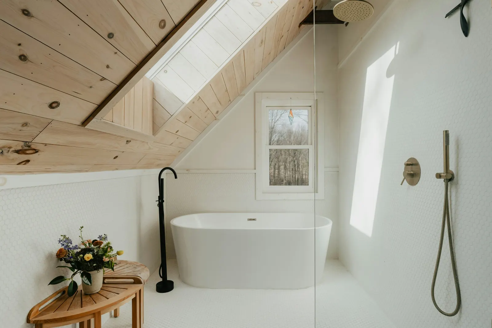 Baño abuhardillado con bañera exenta y ducha