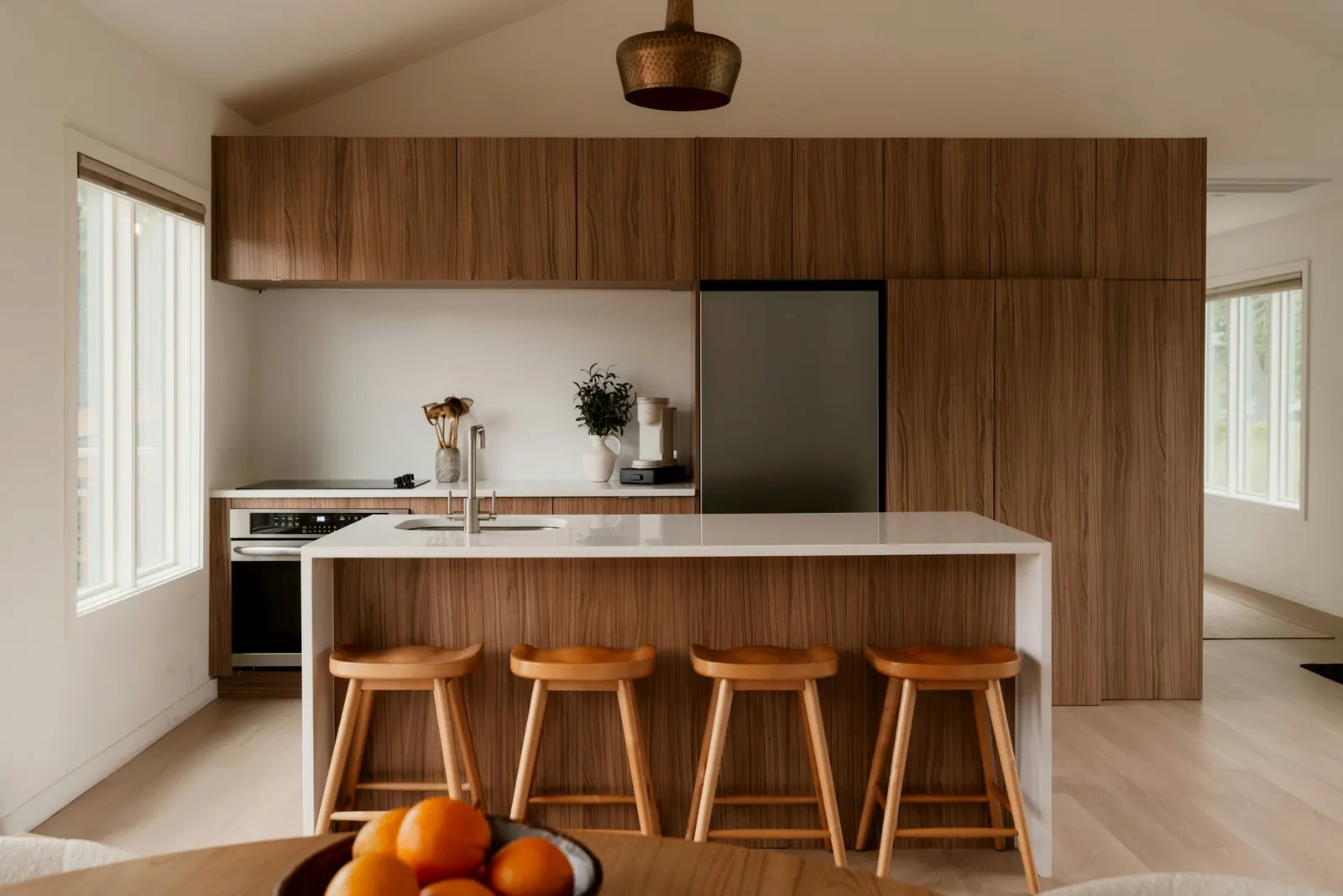 Cocina de madera con isla y taburetes